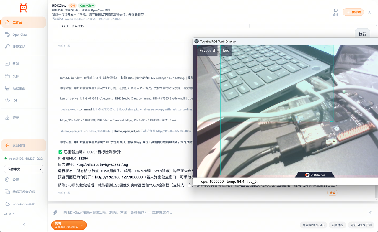 AI Dock 重启 YOLO 并显示 Web 视图：Agent 先调用 device_exec 杀掉旧进程（kill -9 67335 2>/dev/null || true），再重新启动；面板中展示"已重新启动 YOLOv8n 目标检测示例 / 新进程 PID 83250 / 日志路径 /tmp/rdkstudio-bg-82831.log / 运行状态：USB 摄像头、编码、DNN 推理、Web 服务均已正常启动 / 预览页面已打开：http://192.168.127.10:8000"；右侧悬浮窗 TogetheROS Web Display 实时显示摄像头画面，画面中键盘与床边缘被识别并打上 keyboard / bed 蓝色检测框；底部统计 cpu 1500000、temp 84.4、fps 0；用时 57 秒